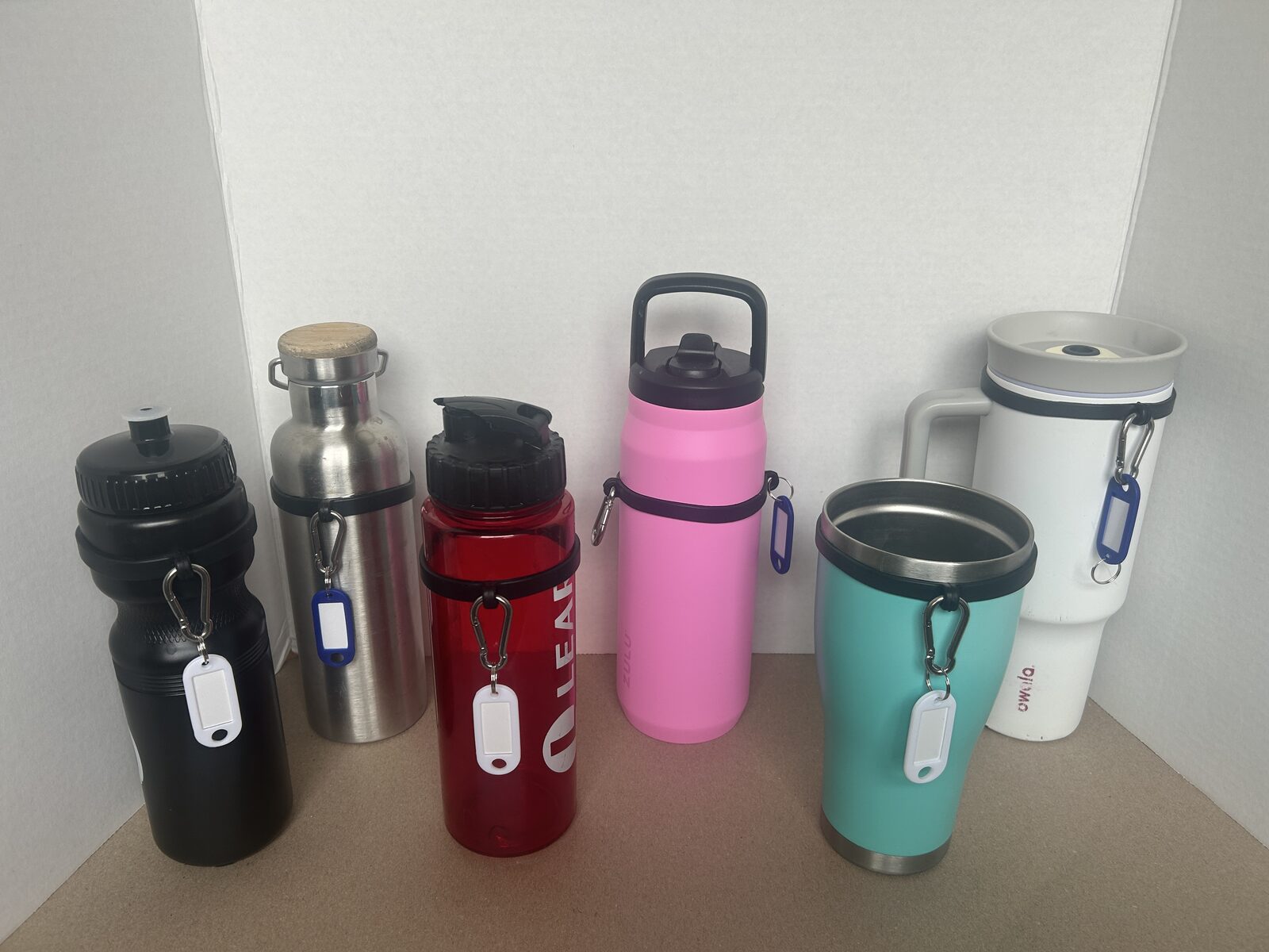 Silicone water bottle sling attached to six different bottle and tumbler shapes and sizes